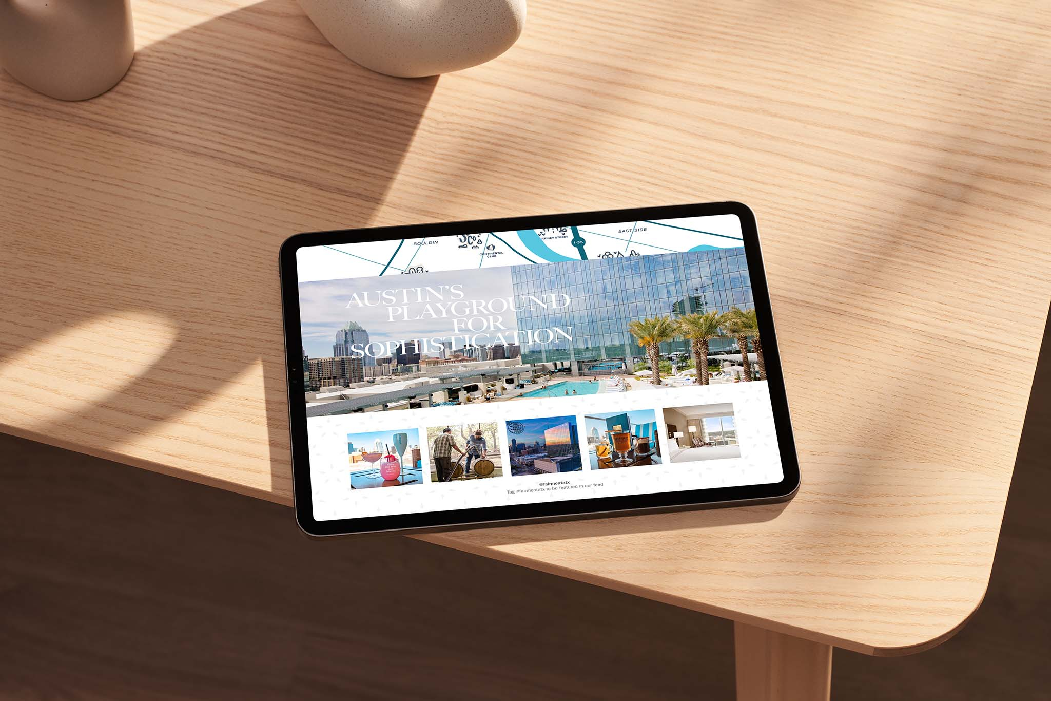 A tablet rests on a wooden table, displaying a turnkey website for a luxury hotel or resort with images of outdoor amenities and a modern glass building.